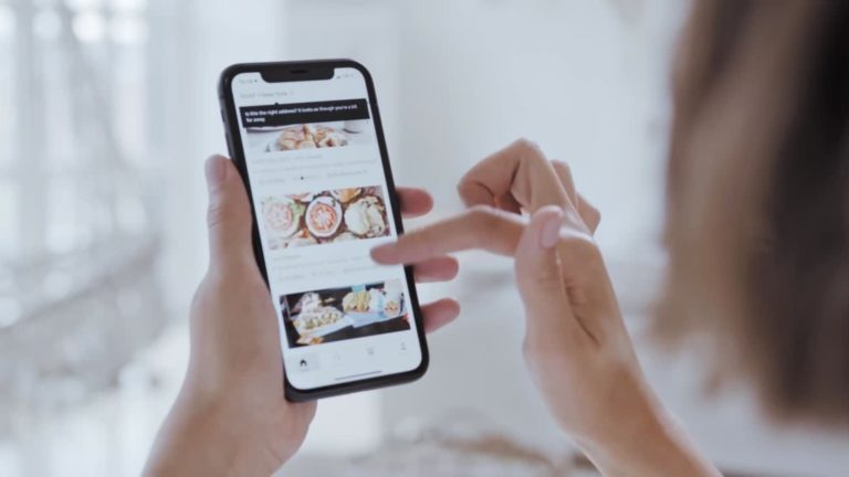 Frau sieht sich Produkte auf dem Smartphone an. Diese Bild soll die Nutzung des WhatsApp for Business Produktkatalogs darstellen