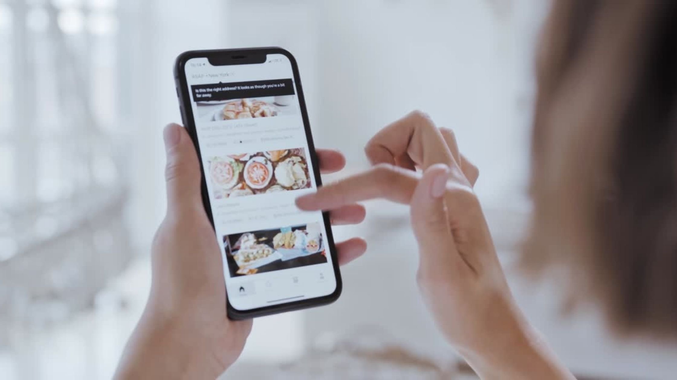 Frau sieht sich Produkte auf dem Smartphone an. Diese Bild soll die Nutzung des WhatsApp for Business Produktkatalogs darstellen